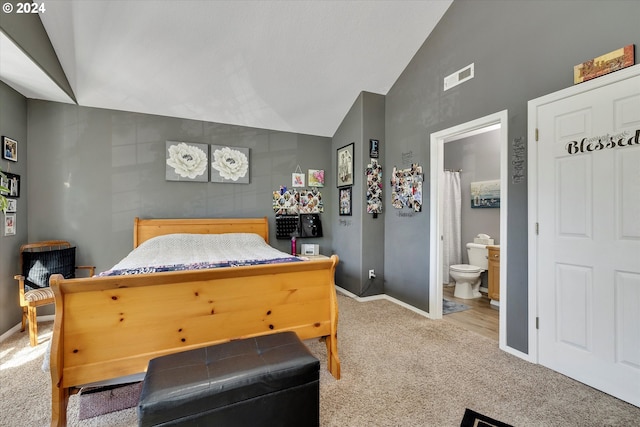 bedroom featuring connected bathroom, vaulted ceiling, and wood-type flooring