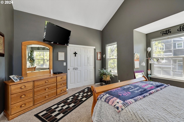 carpeted bedroom with a closet, high vaulted ceiling, and multiple windows