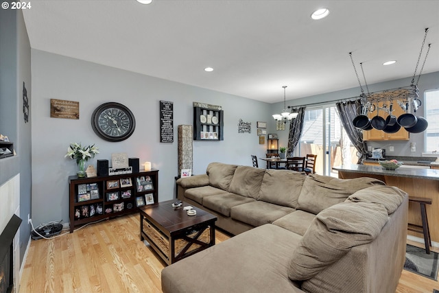 living room with light hardwood / wood-style floors and an inviting chandelier