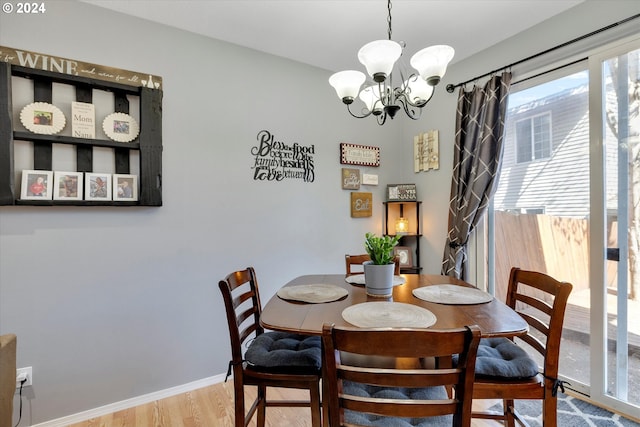 dining room featuring light wood-type flooring and an inviting chandelier