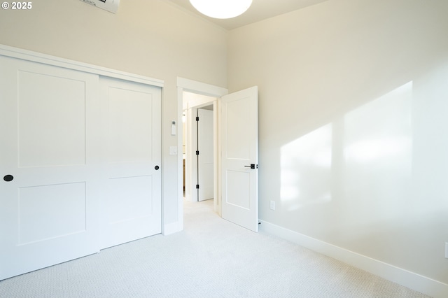 unfurnished bedroom with light carpet and a closet