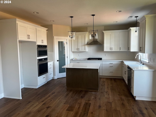 kitchen with a center island, sink, hanging light fixtures, dark hardwood / wood-style flooring, and white cabinets