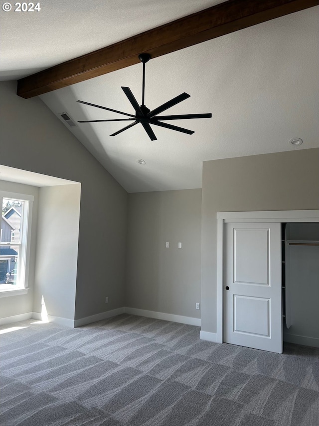 unfurnished bedroom featuring carpet and lofted ceiling with beams