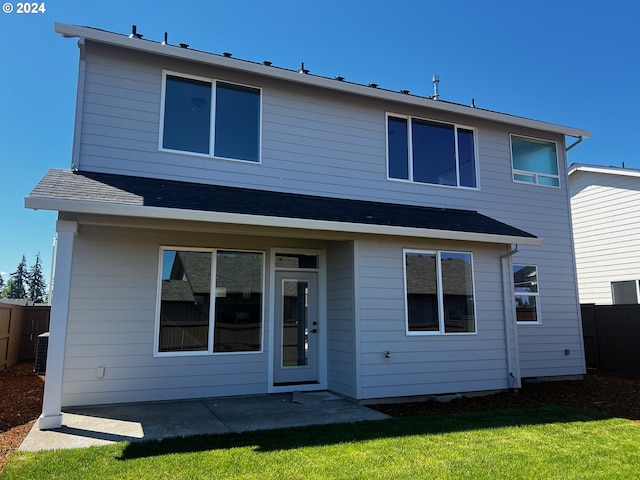 back of property featuring a yard, cooling unit, and a patio