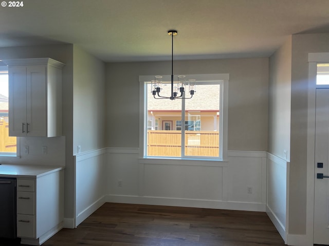 unfurnished dining area with a chandelier and dark wood-type flooring