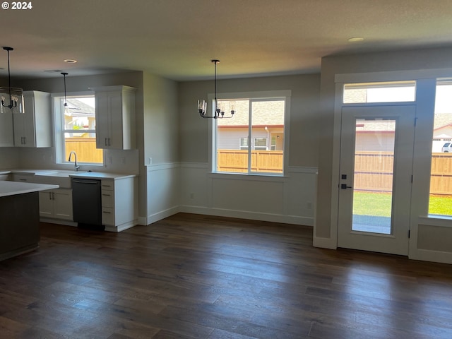 kitchen featuring decorative light fixtures, sink, white cabinetry, and black dishwasher