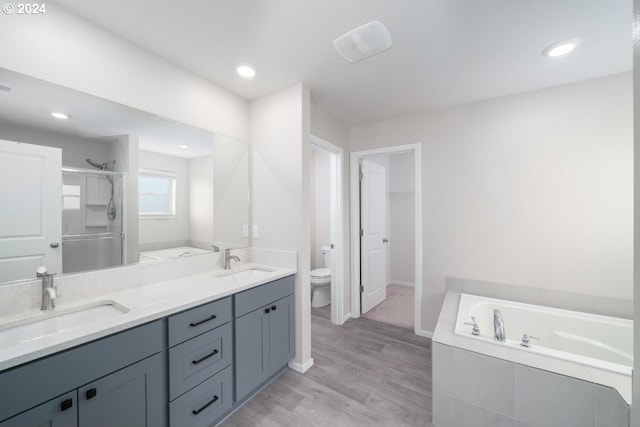 full bathroom with vanity, hardwood / wood-style flooring, toilet, and plus walk in shower