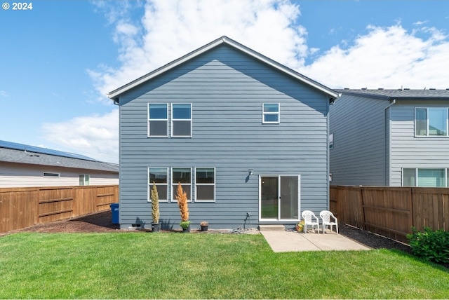 rear view of house with a patio and a yard