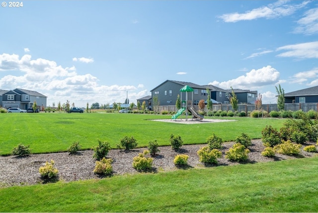 view of property's community with a playground and a yard