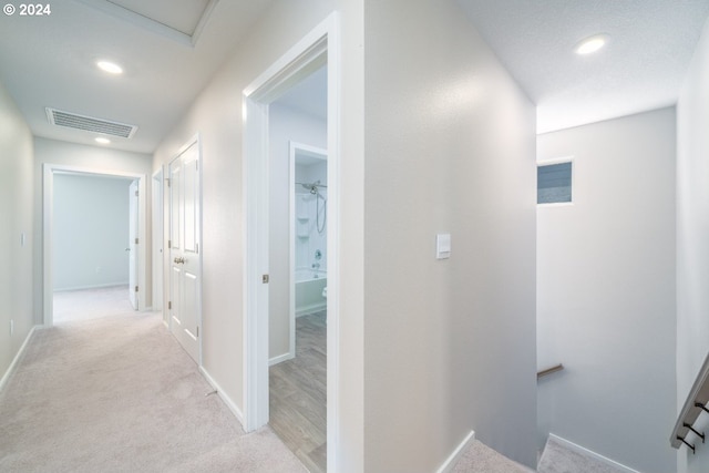 hallway featuring light carpet