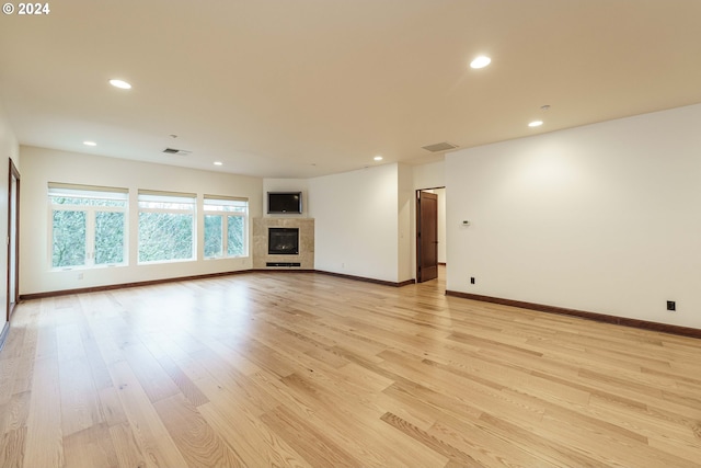 unfurnished living room with a fireplace and light hardwood / wood-style flooring