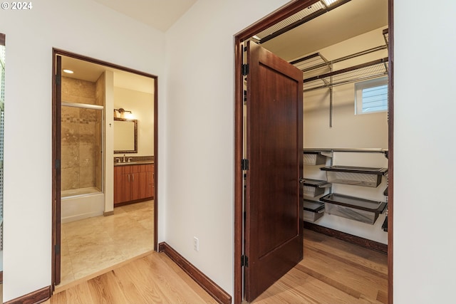 hallway with sink and light hardwood / wood-style floors