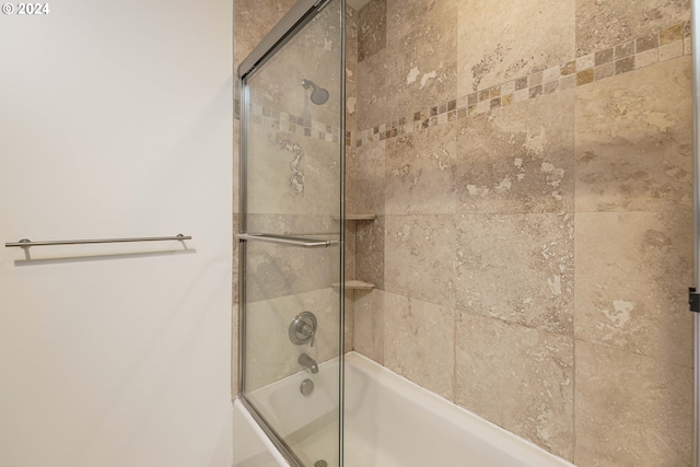 bathroom featuring combined bath / shower with glass door