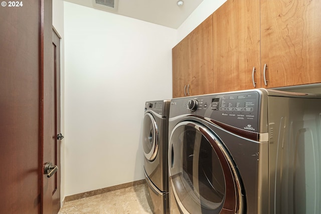 laundry area with cabinets and washing machine and clothes dryer