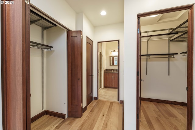 corridor featuring light wood-type flooring and sink