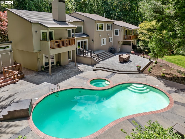 view of swimming pool with a patio area and an in ground hot tub