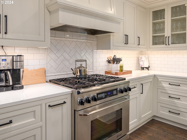 kitchen featuring dark hardwood / wood-style flooring, high end stainless steel range, white cabinetry, backsplash, and custom range hood