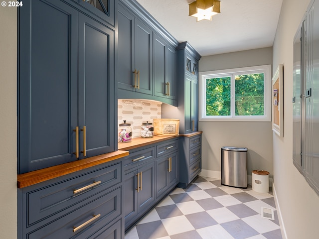 interior space with decorative backsplash and blue cabinetry