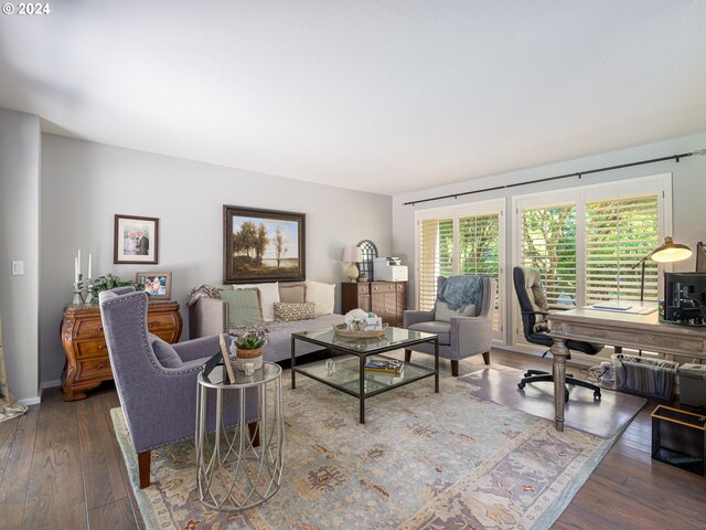 living room with plenty of natural light and dark hardwood / wood-style flooring