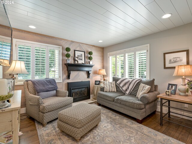 living room featuring a wealth of natural light, wooden walls, and hardwood / wood-style floors