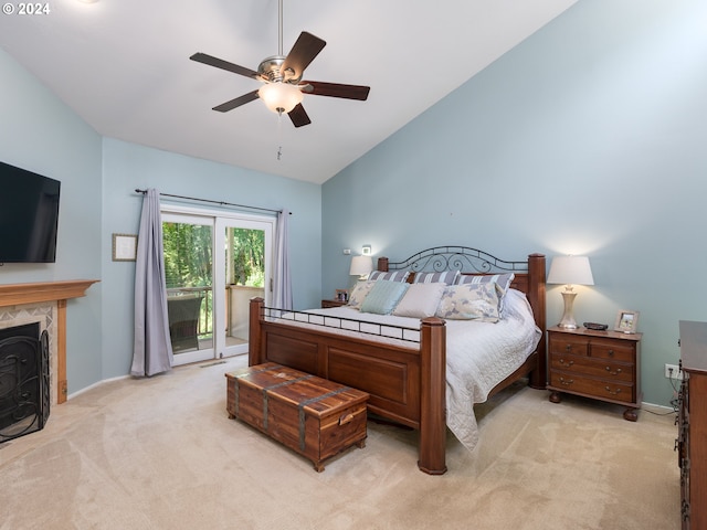 bedroom with vaulted ceiling, a fireplace, access to outside, light colored carpet, and ceiling fan