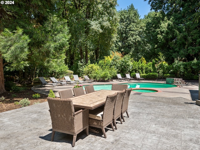 view of pool featuring a patio area and an in ground hot tub