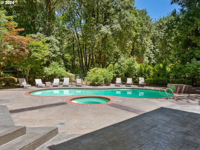 view of pool featuring an in ground hot tub and a patio