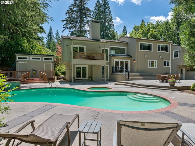 view of swimming pool with an in ground hot tub, a shed, and a patio area