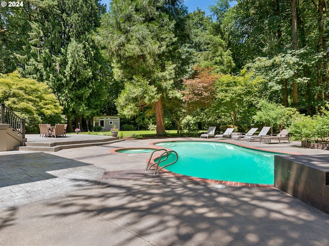 view of swimming pool with an in ground hot tub and a patio area