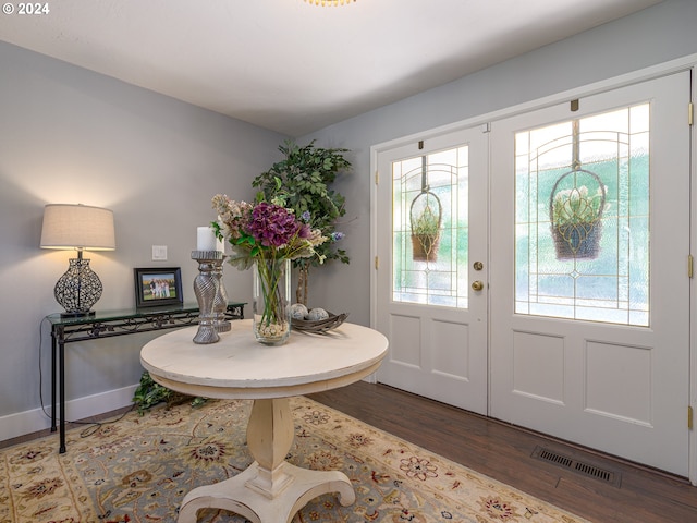 foyer entrance with a wealth of natural light, dark hardwood / wood-style floors, and french doors