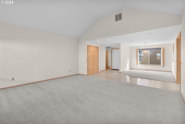 tiled spare room featuring an inviting chandelier and high vaulted ceiling