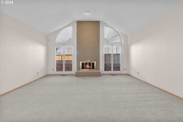 unfurnished living room featuring light carpet, lofted ceiling, and a fireplace