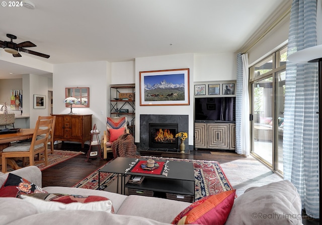 living room with ceiling fan, a high end fireplace, and wood-type flooring