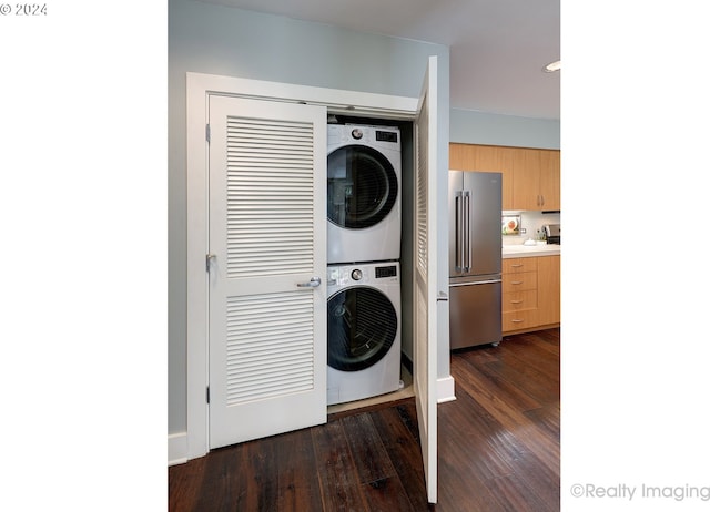 washroom featuring stacked washer / drying machine and dark hardwood / wood-style floors