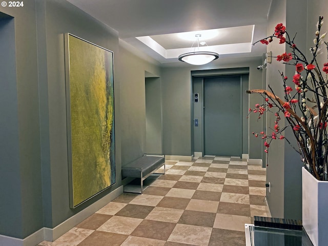 entryway with a raised ceiling and elevator