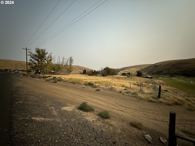 view of street with a rural view and a mountain view