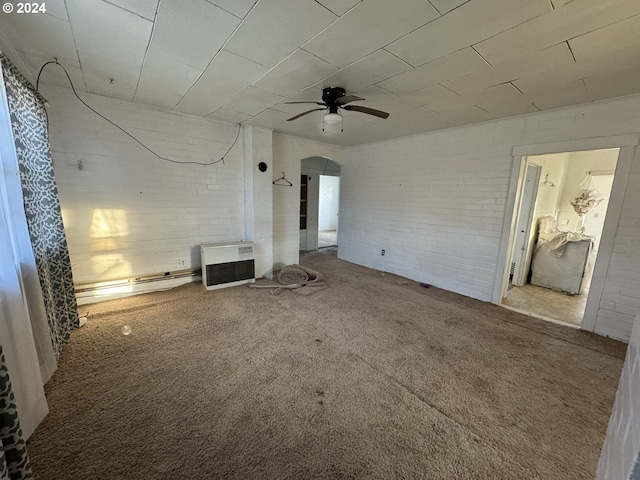 66350 Upper Rock Creek Rd, Arlington, OR 97812 - unfurnished living room featuring brick wall, arched walkways, a ceiling fan, and carpet floors