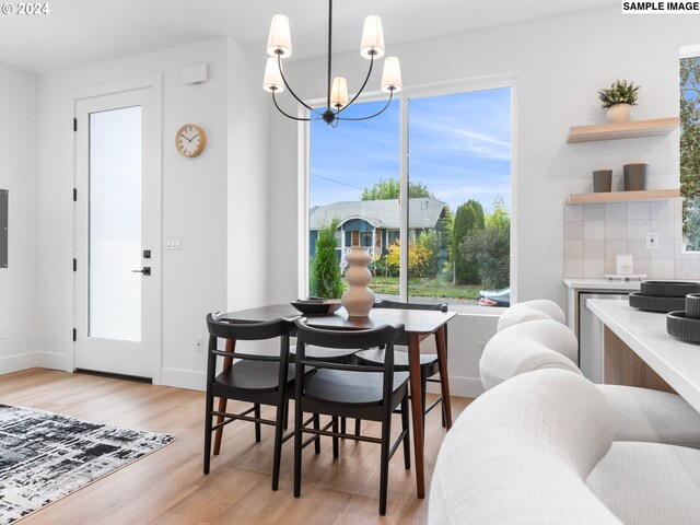 dining area with an inviting chandelier, plenty of natural light, and light hardwood / wood-style flooring