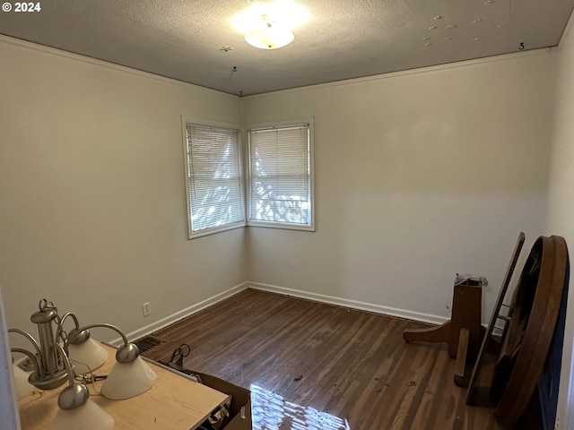 empty room with dark hardwood / wood-style flooring and a textured ceiling