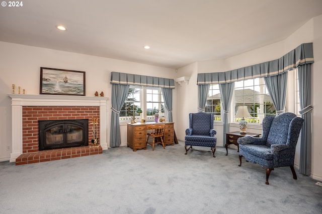 living area featuring plenty of natural light, a fireplace, and carpet flooring