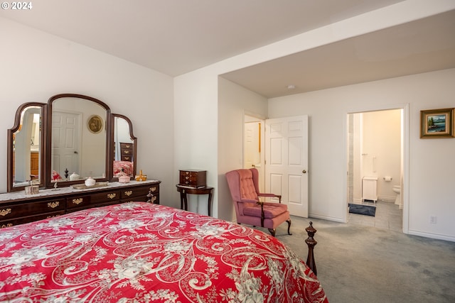 carpeted bedroom featuring baseboards and ensuite bath