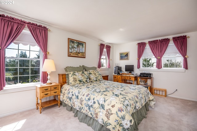 bedroom with multiple windows, baseboards, and light colored carpet