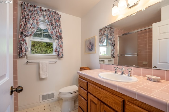 full bath featuring toilet, a shower with shower door, plenty of natural light, and visible vents