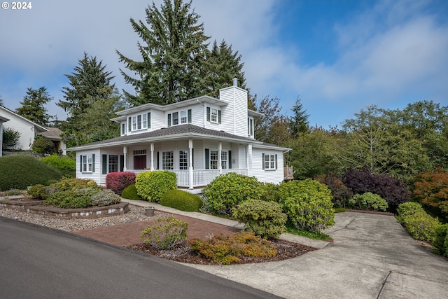 view of front of house featuring covered porch and a chimney