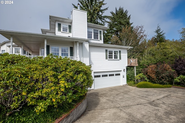 view of front of house with a garage, driveway, and a chimney