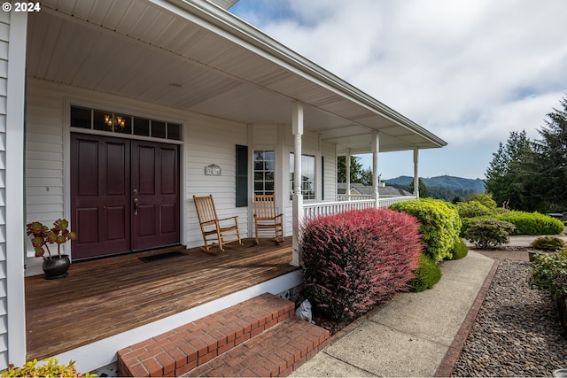 property entrance with covered porch and a mountain view