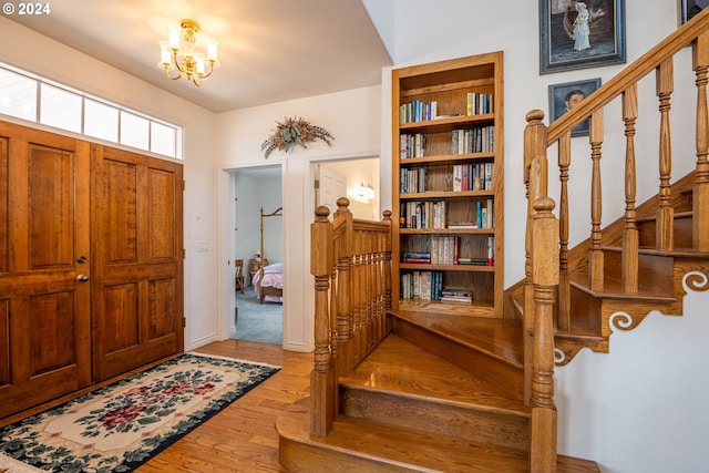 entrance foyer featuring stairway, an inviting chandelier, and light wood-style floors