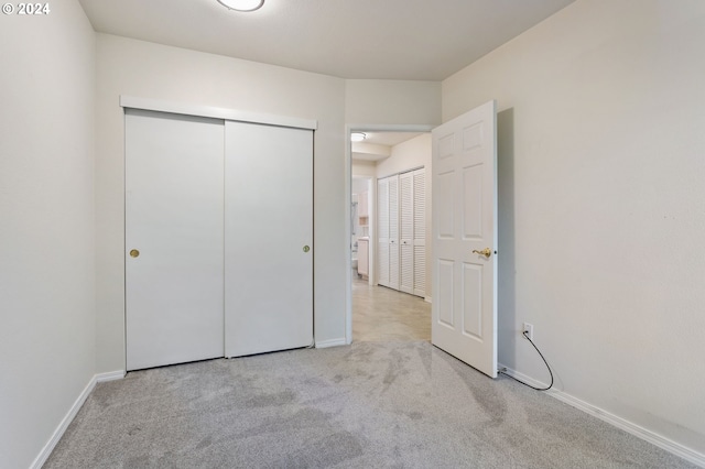 unfurnished bedroom featuring light carpet