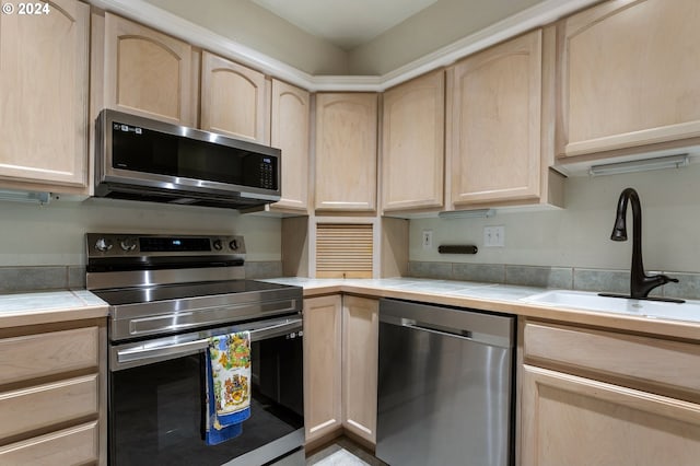 kitchen with tile countertops, light brown cabinets, sink, and stainless steel appliances