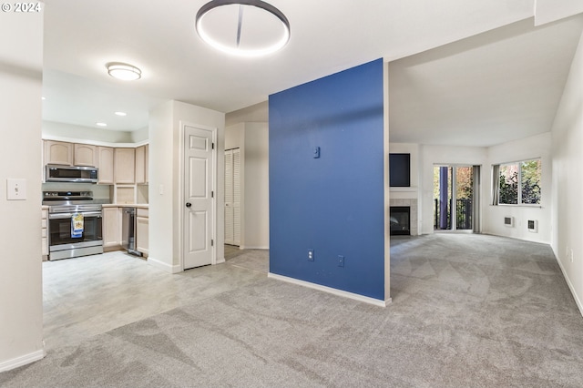 unfurnished living room featuring a tiled fireplace and light carpet